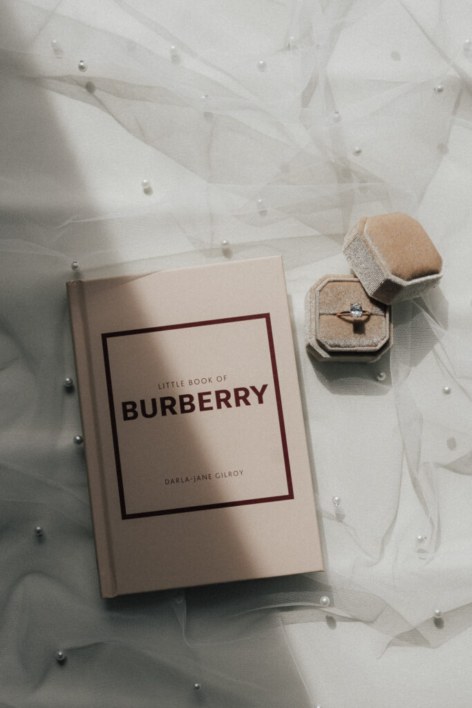 Close-up of a Burberry-Book and wedding rings, captured by Maria Bruckmaier Wedding Photography.